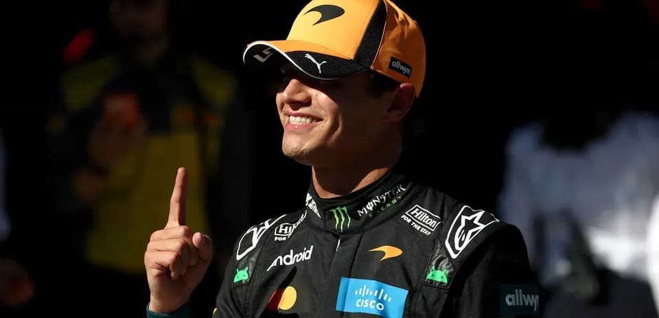 Driver celebrating with finger raised in paddock