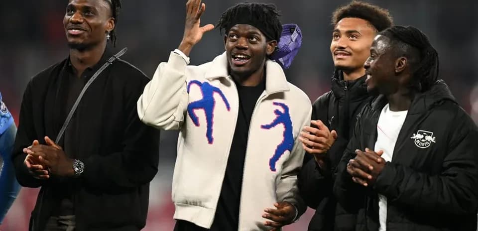 Four players interacting on the pitch after match
