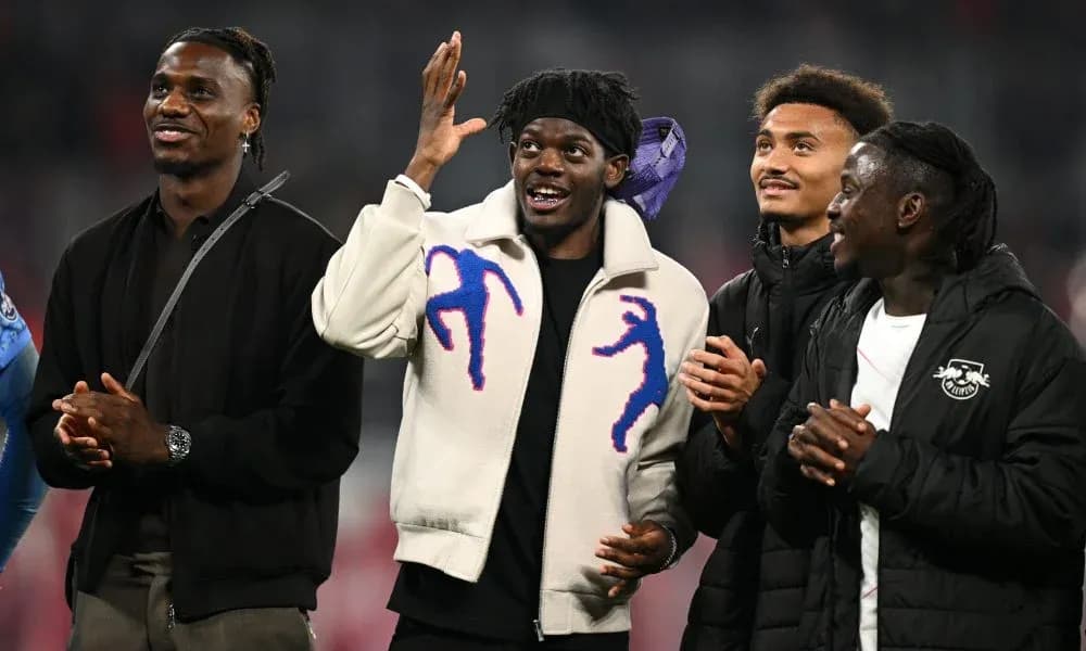 Four players interacting on the pitch after match