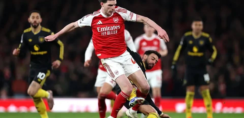 Arsenal player evading a tackle during match