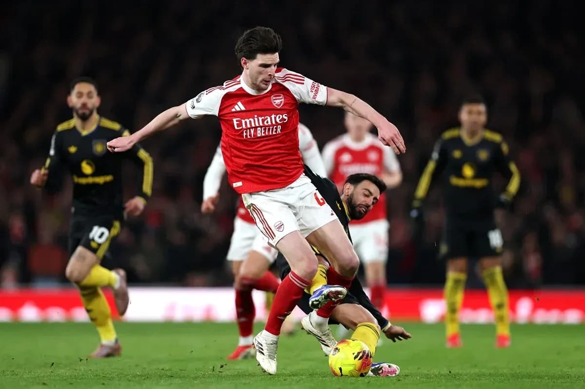 Arsenal player evading a tackle during match