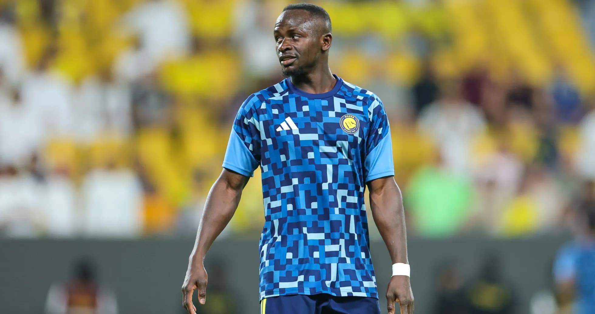 Player in blue patterned jersey during match warm-up