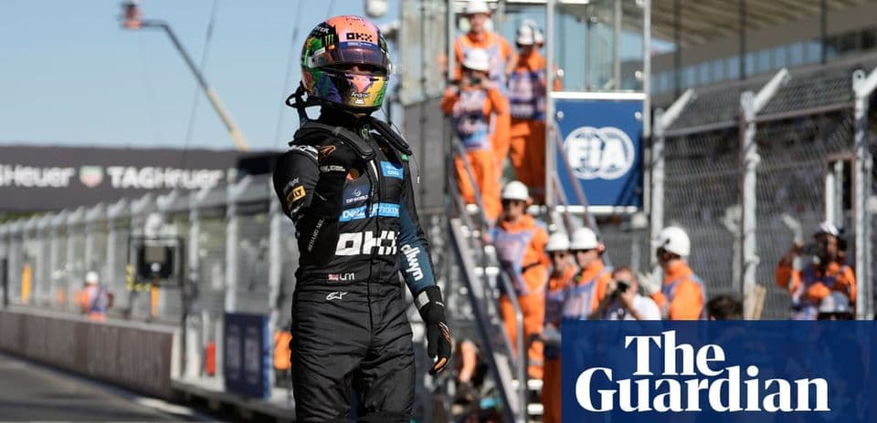Driver celebrating on track with pit crew in background