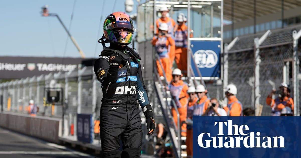 Driver celebrating on track with pit crew in background