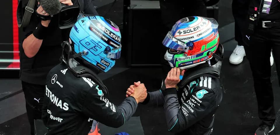 Two Formula 1 drivers shaking hands on podium