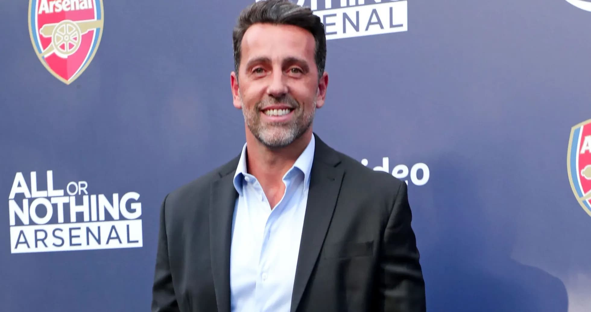 Person smiling at Arsenal event backdrop
