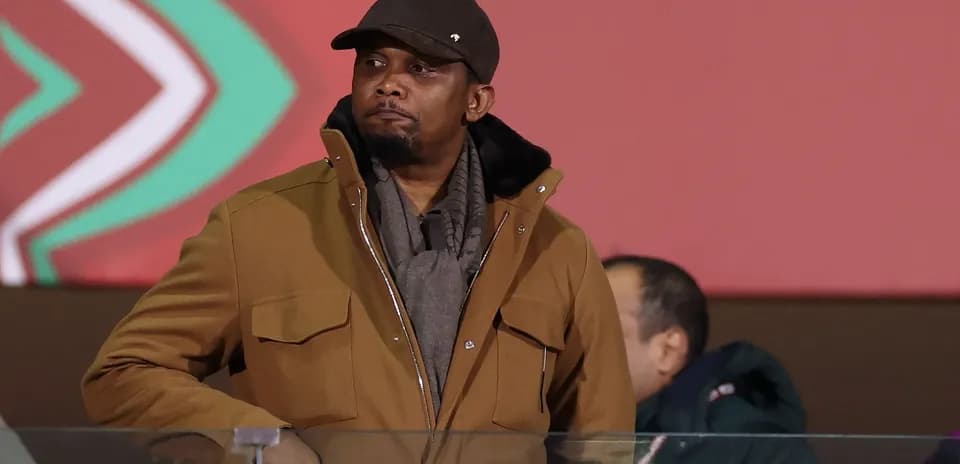 Man in brown jacket observing event from stands