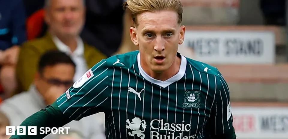 Player in green kit dribbling the ball during match