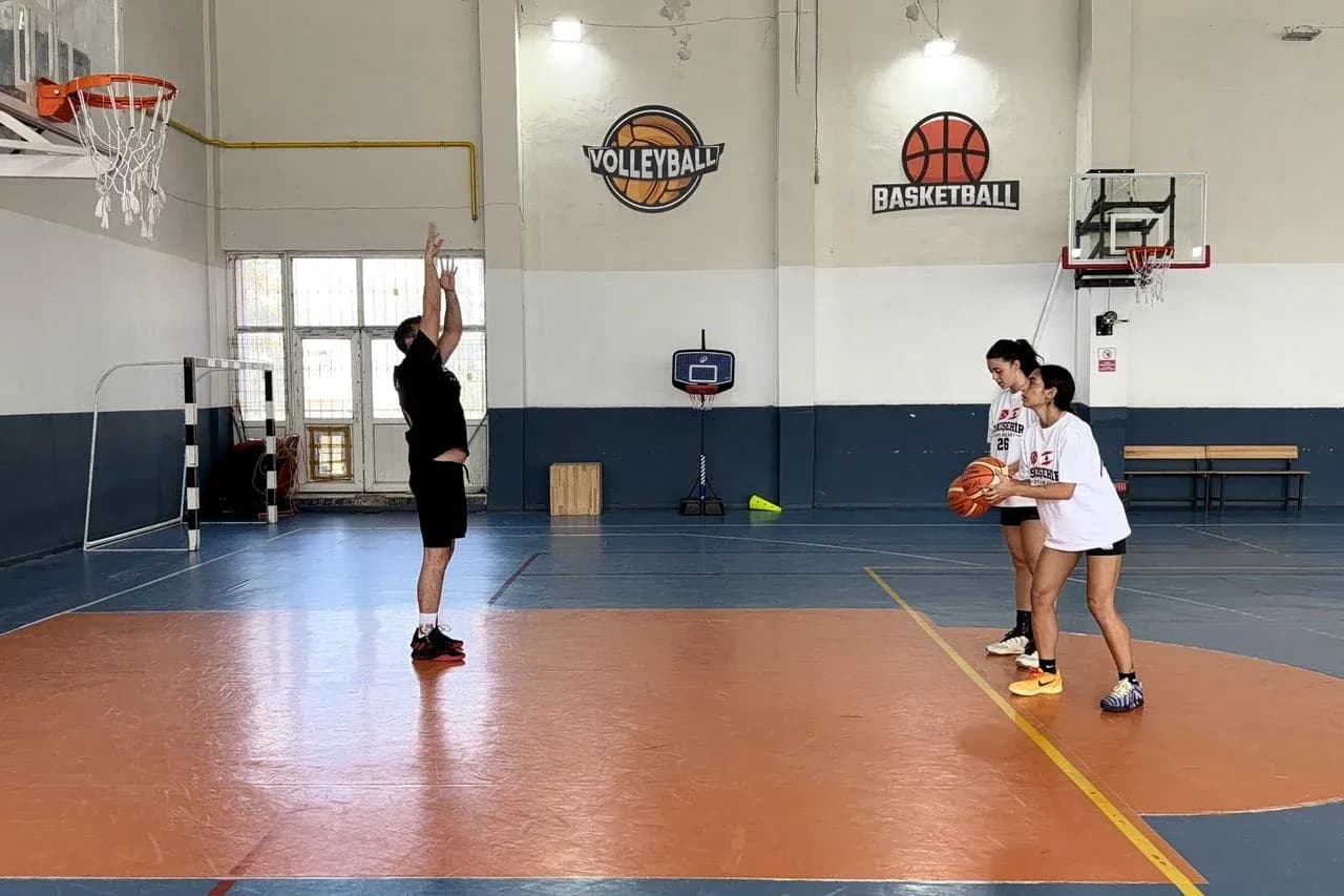 Player practicing a shot with two teammates observing