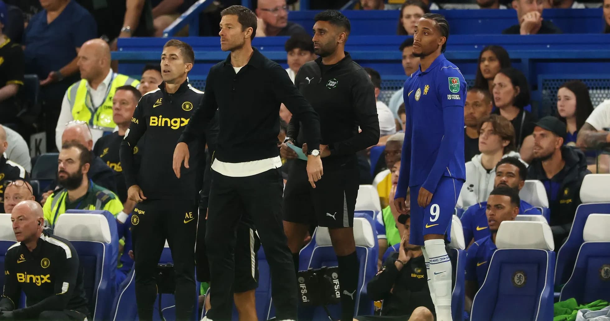 Coaches and player on Chelsea bench during match