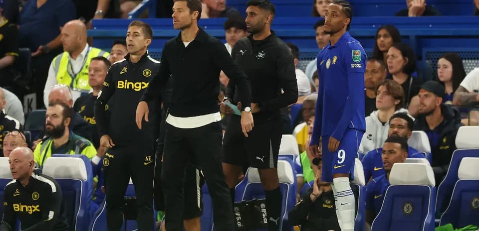 Coaches and player on Chelsea bench during match