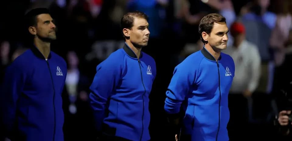Three tennis players standing together in blue jackets