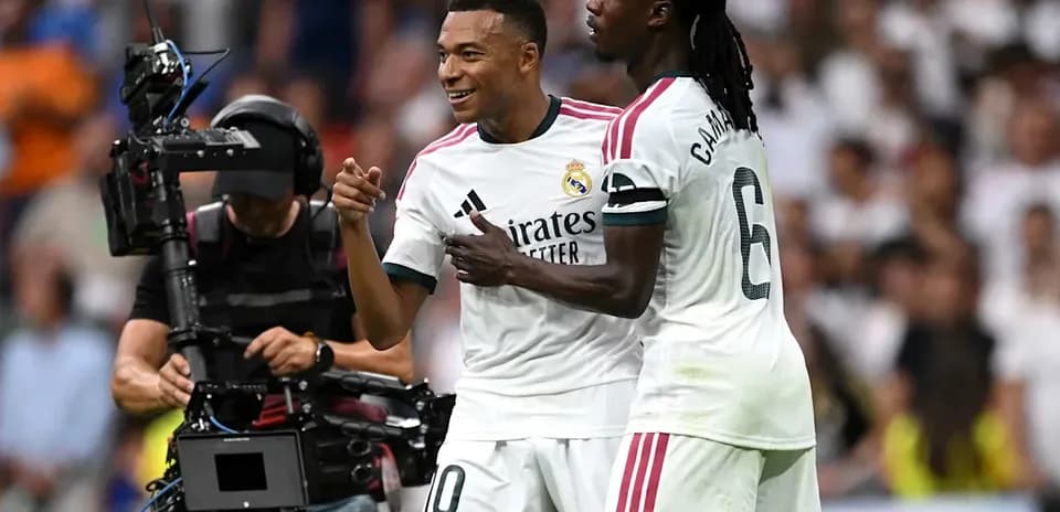 Players celebrating during a match with camera crew
