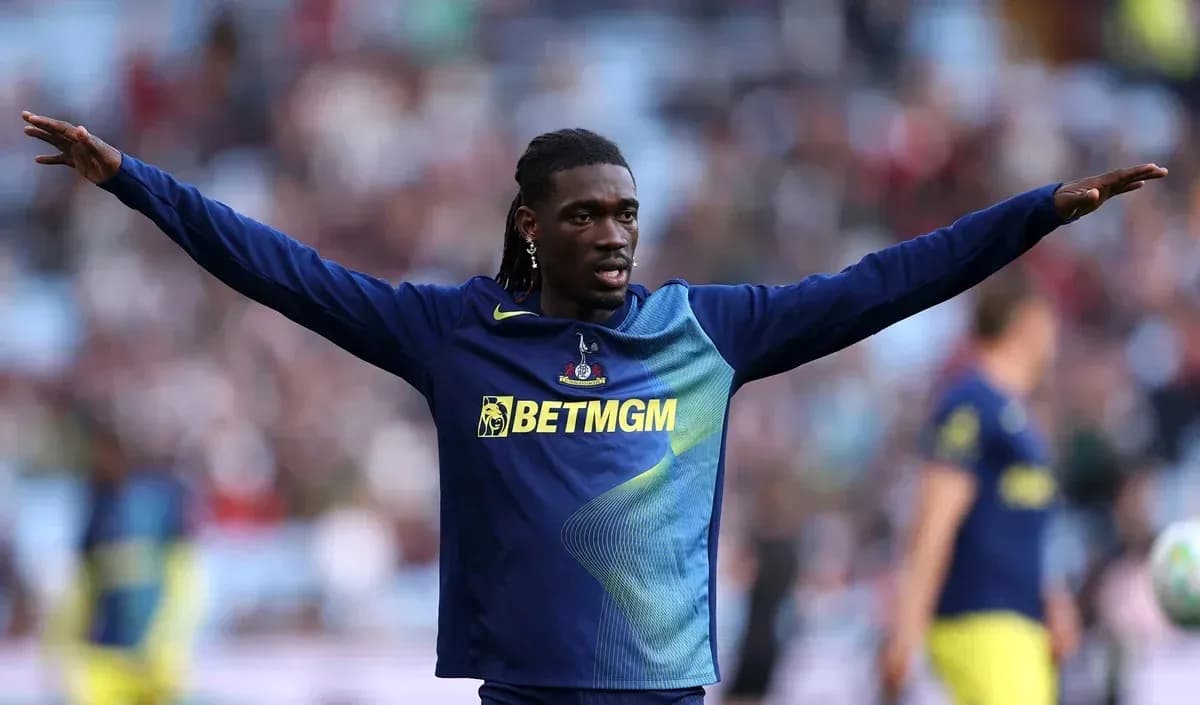 Player warming up with arms outstretched on pitch