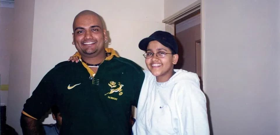 Two people posing together in a room