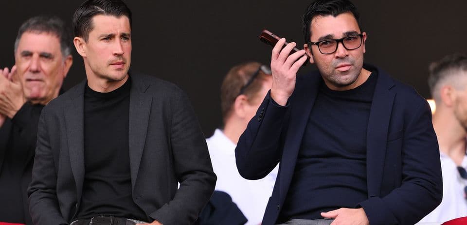 Two men seated in stands during an event