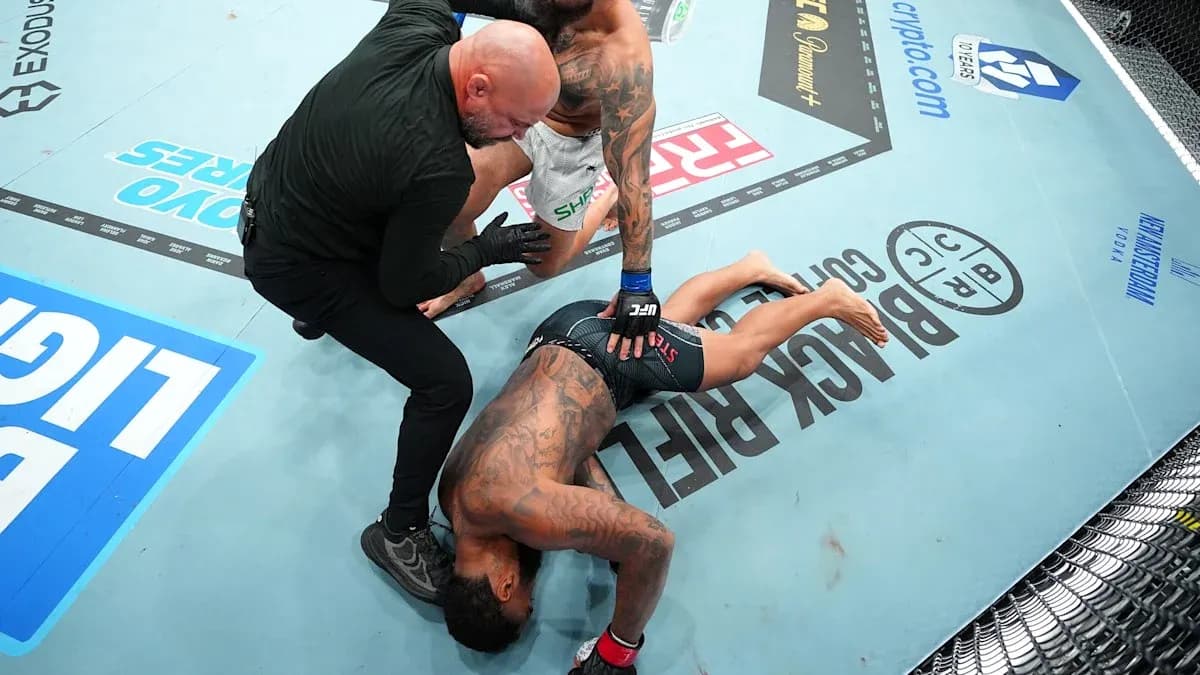Fighter on the mat with referee assisting