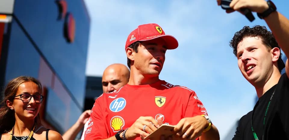 Driver in Ferrari shirt interacting with fans