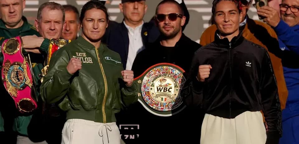 Katie Taylor and opponent at weigh-in holding championship belts
