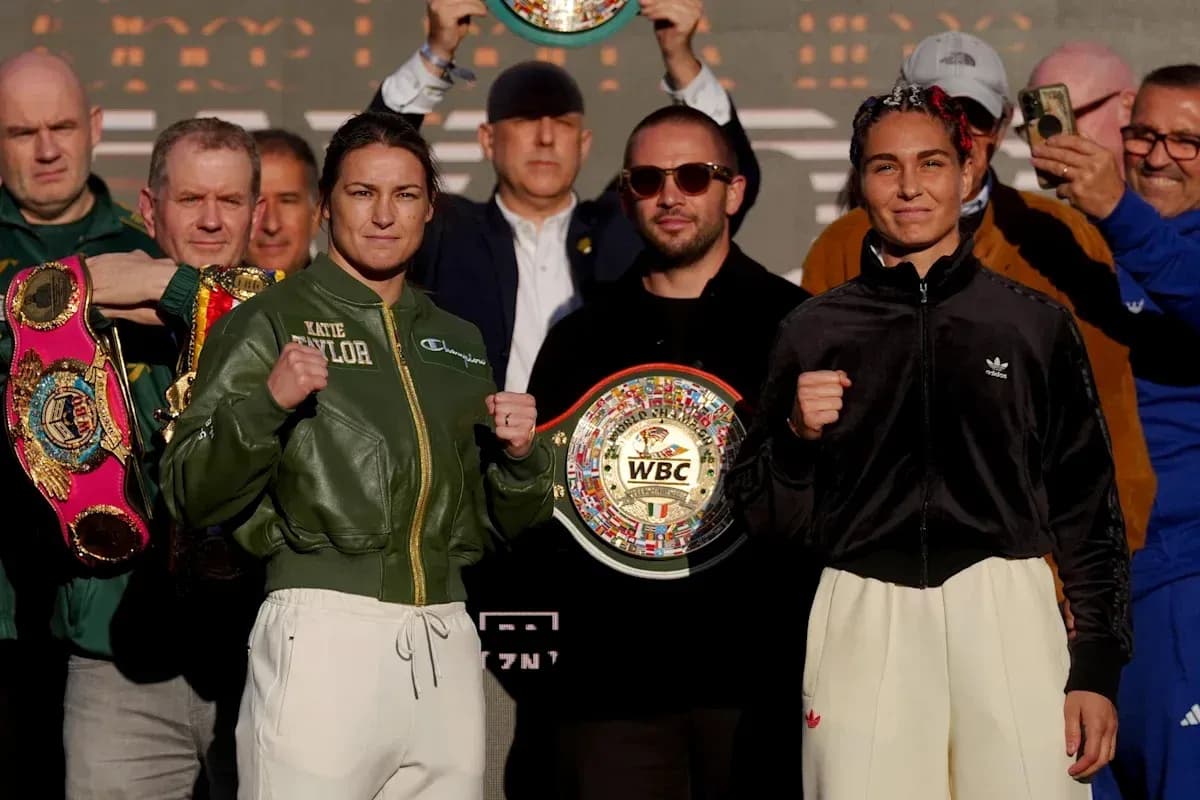 Katie Taylor and opponent at weigh-in holding championship belts
