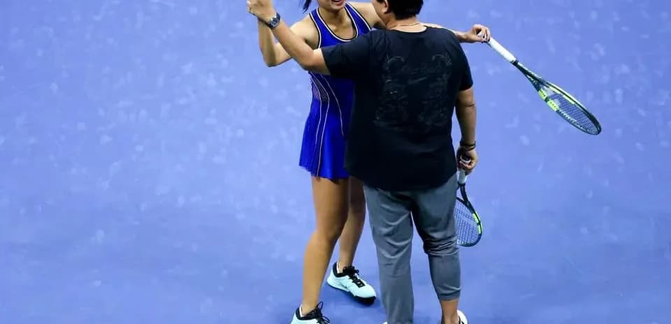 Player celebrating with coach on tennis court