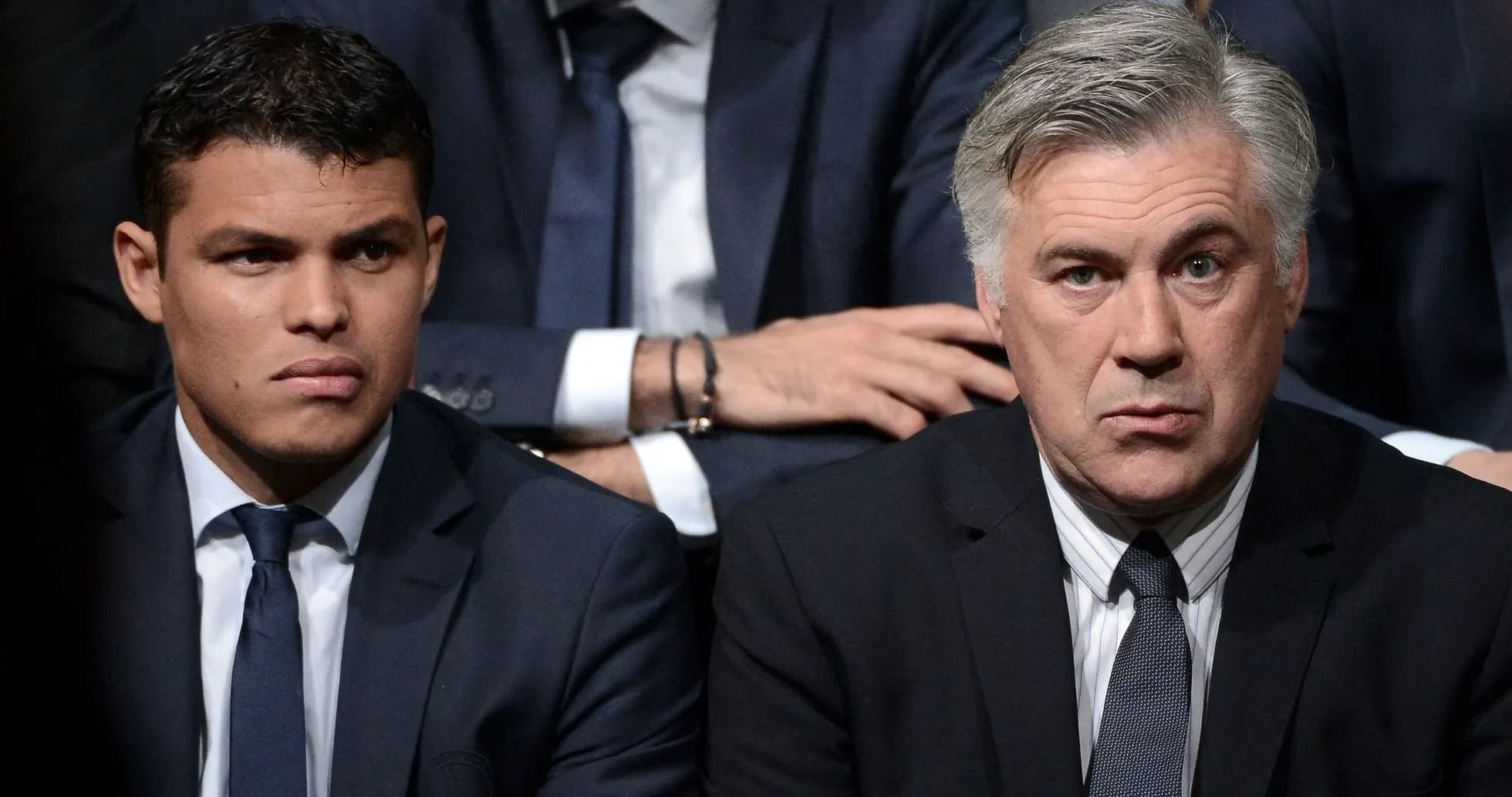 Two men in suits seated at an event