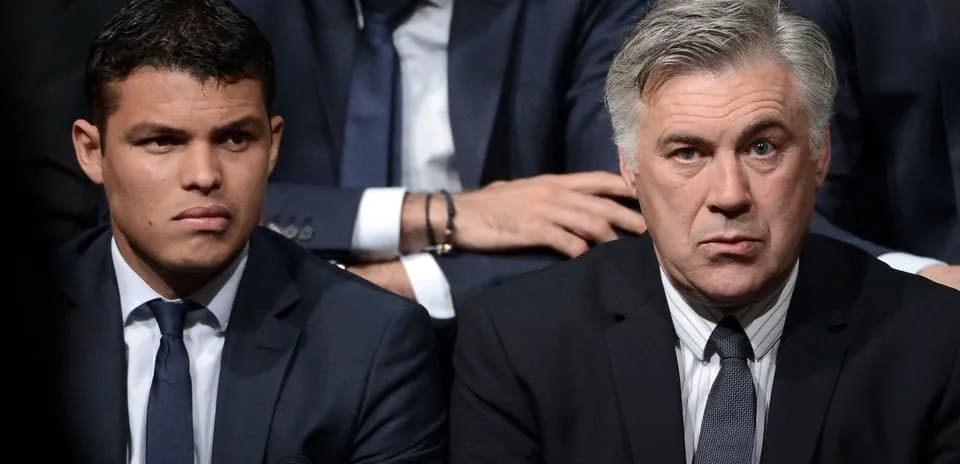 Two men in suits seated at an event