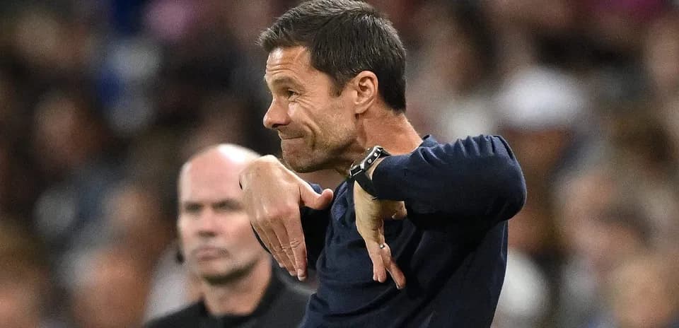 Coach gesturing during a match with referee nearby