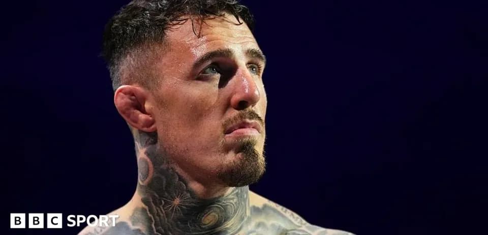 Tattooed fighter looking up in arena