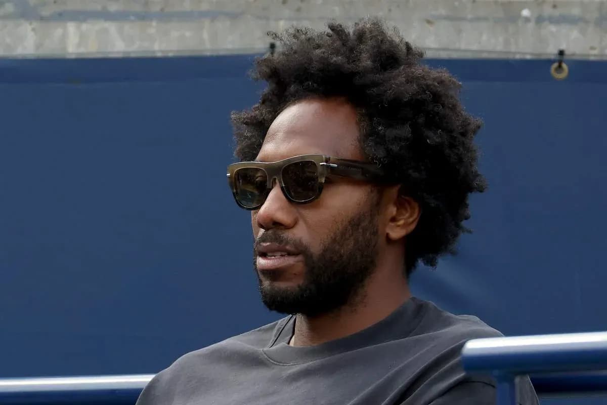 Man wearing sunglasses sitting in stadium seats