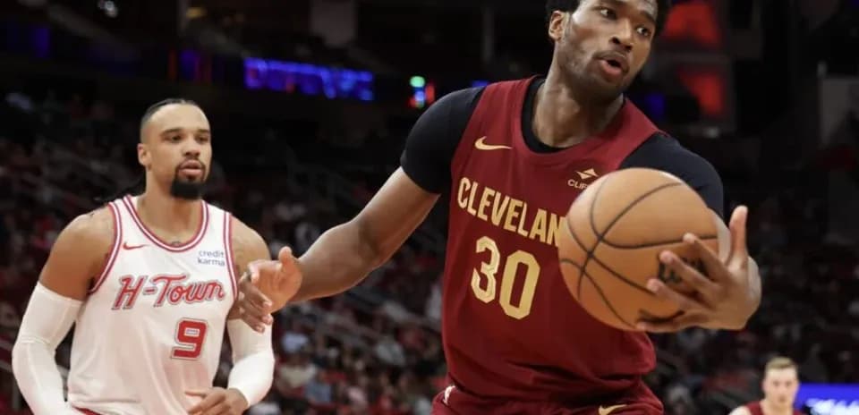 Cleveland player dribbling basketball past opponent