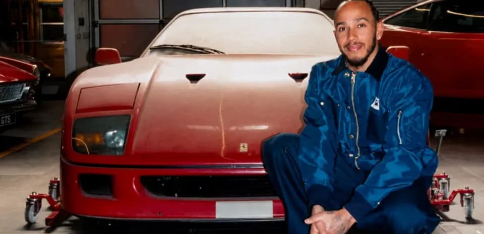 Man crouching next to a red sports car