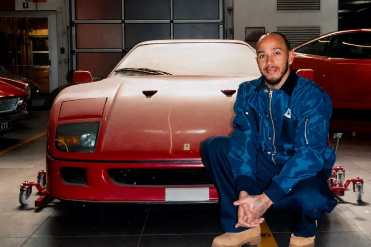 Man crouching next to a red sports car