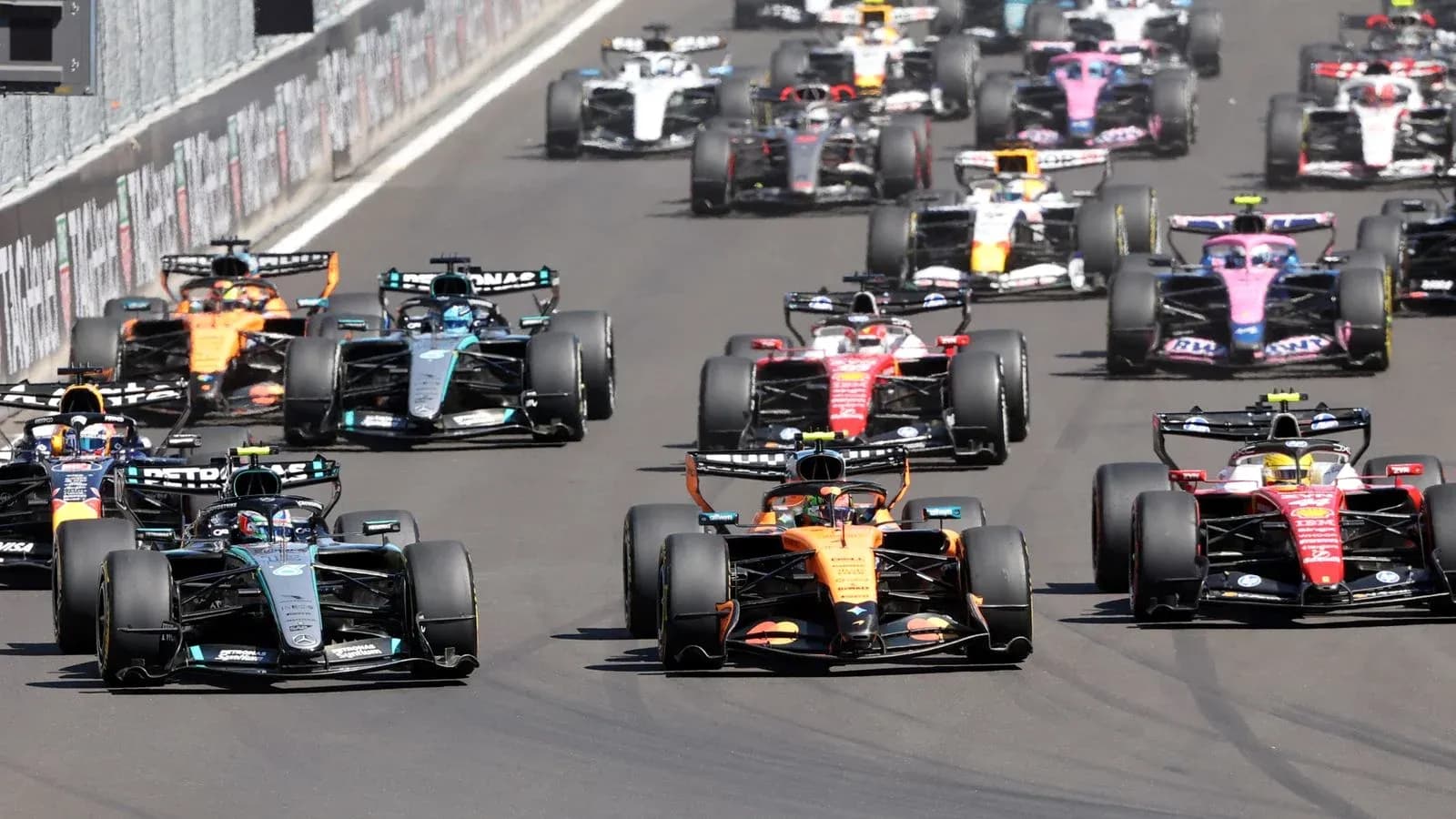 Multiple Formula 1 cars racing closely on track