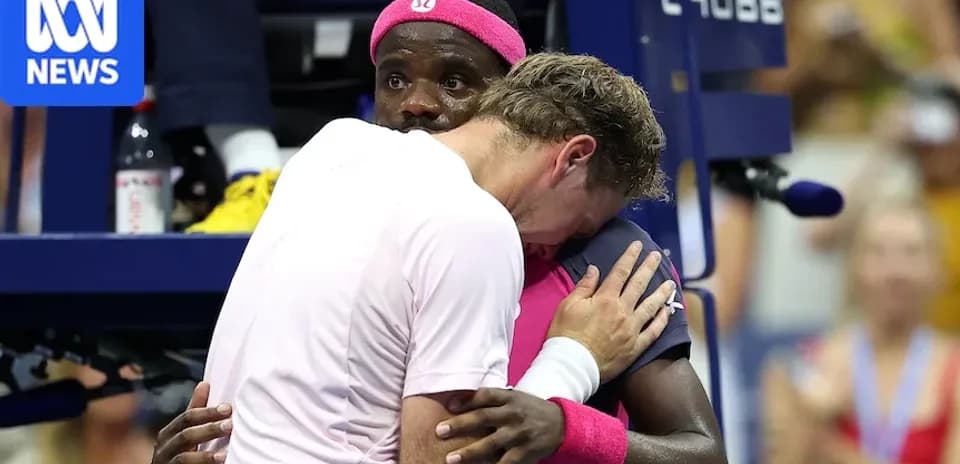 Two tennis players embracing at the court