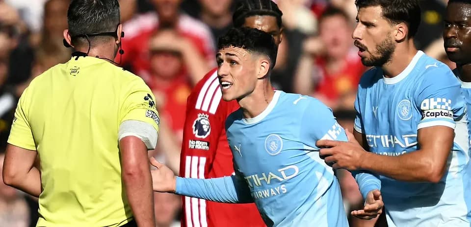Manchester City players arguing with referee during match