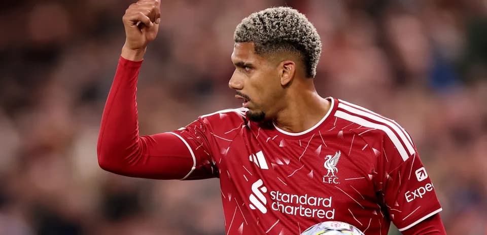 Player gesturing during match in Liverpool kit
