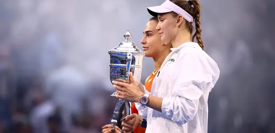Two tennis players holding trophy after match