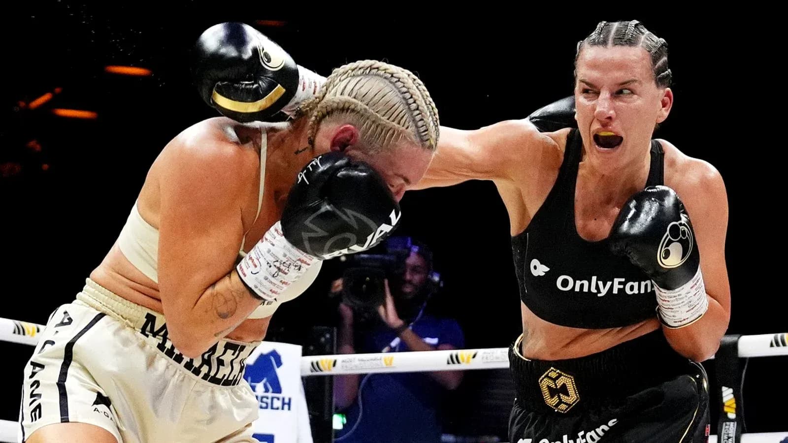 Two female boxers exchanging punches in the ring Two female boxers exchanging punches in the ring