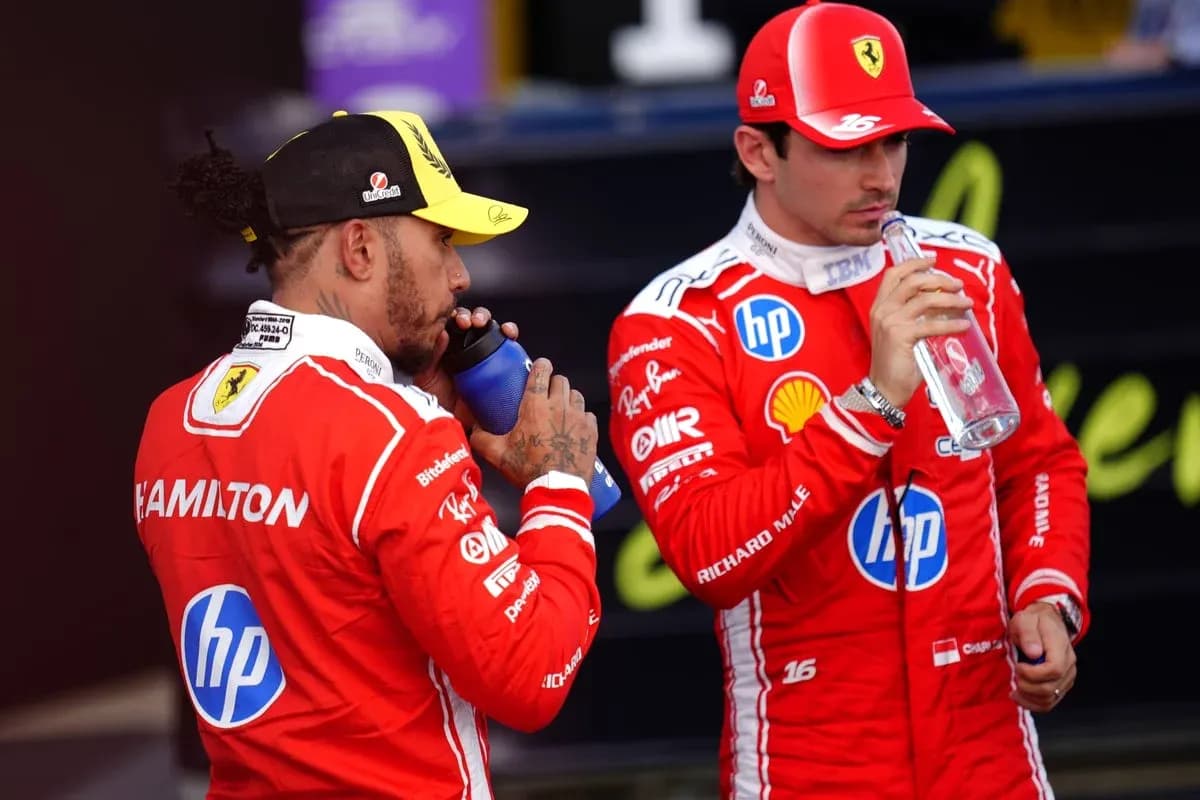 Two Formula 1 drivers hydrating in team uniforms Two Formula 1 drivers hydrating in team uniforms
