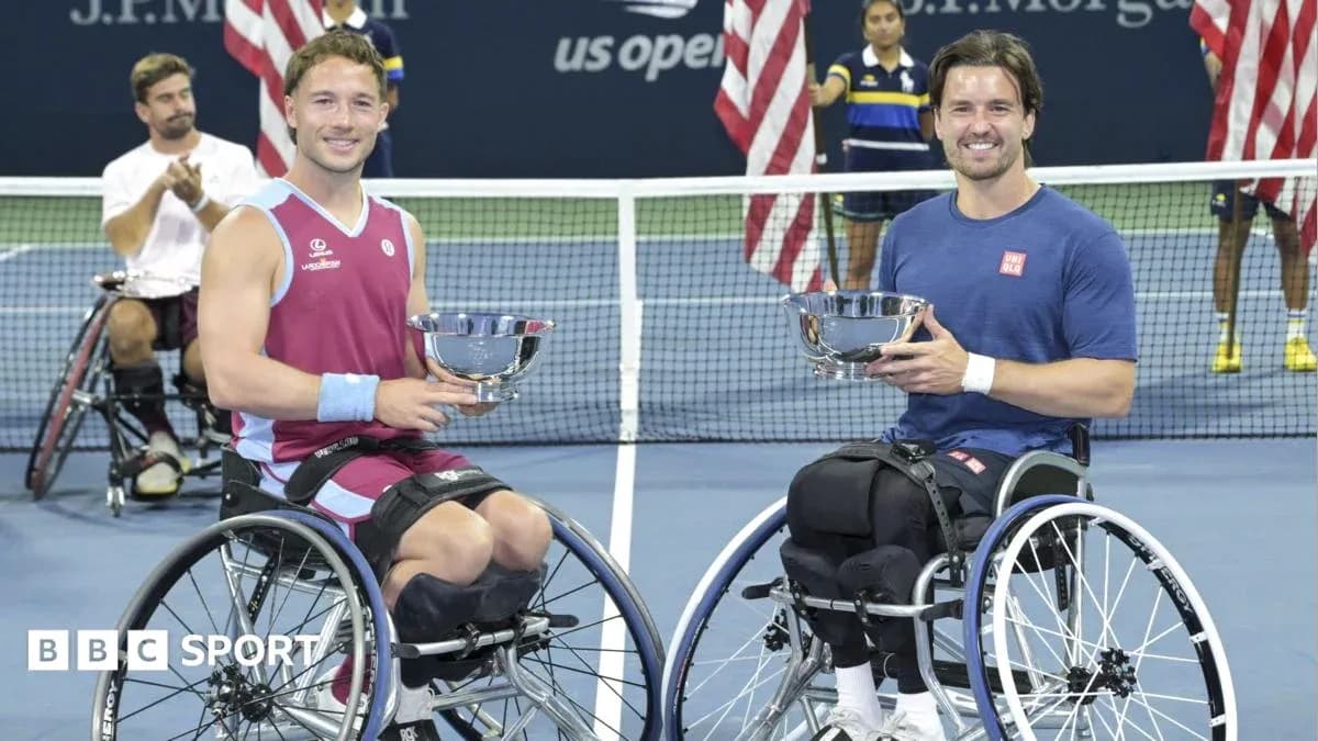 Two wheelchair tennis players holding trophies on court Two wheelchair tennis players holding trophies on court