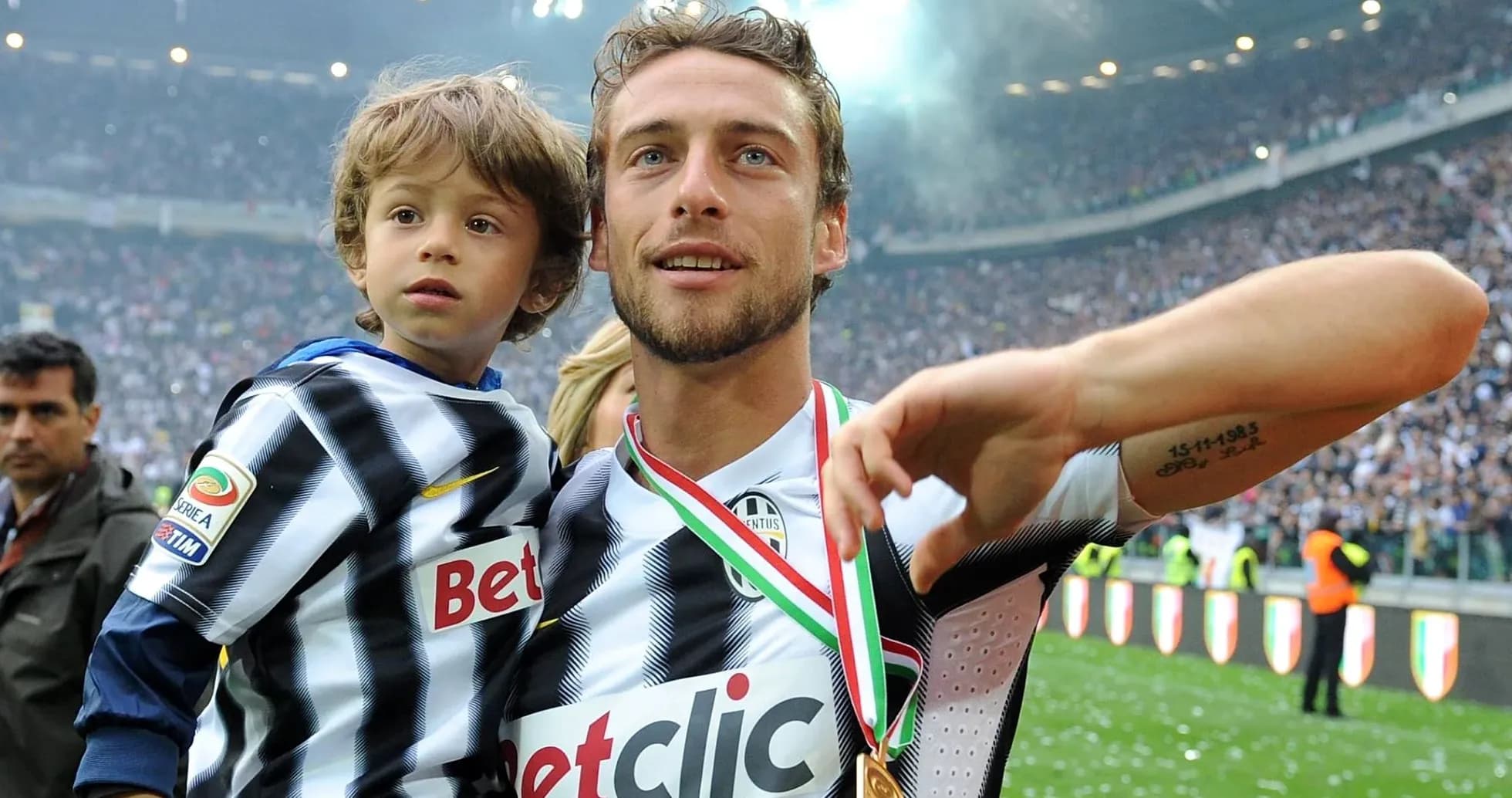Player holding child on the field with medal Player holding child on the field with medal