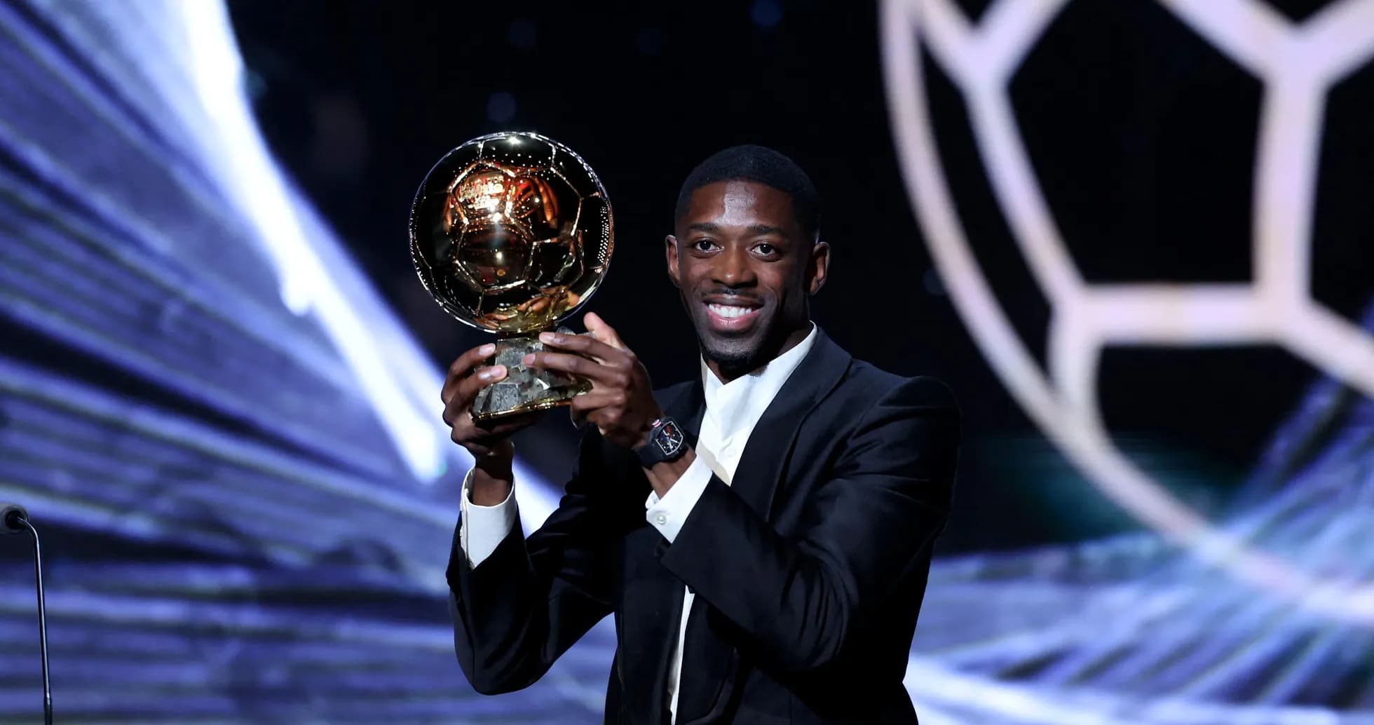 Player holding Ballon d'Or trophy on stage Player holding Ballon d'Or trophy on stage