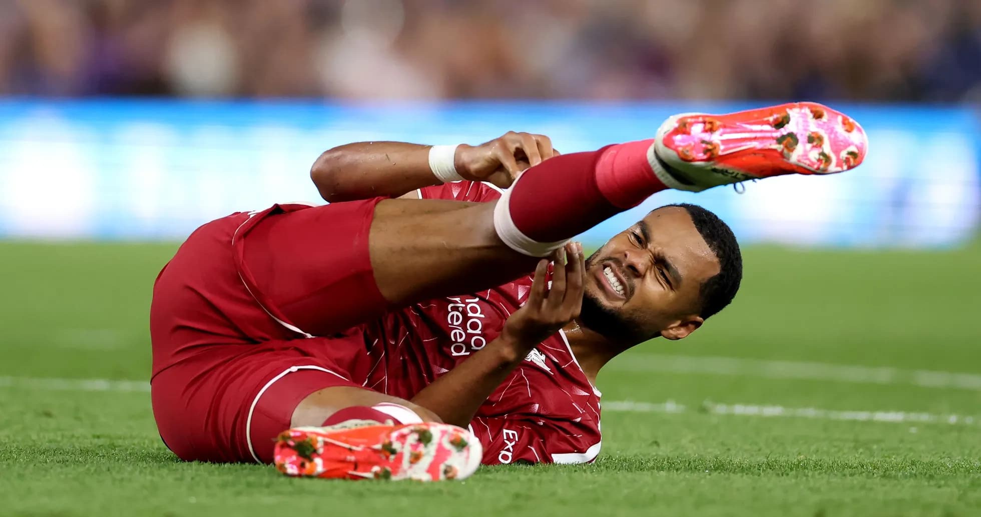 Player from Liverpool lying on the pitch injured Player from Liverpool lying on the pitch injured