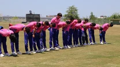 Cricket team bowing before training session on field Cricket team bowing before training session on field