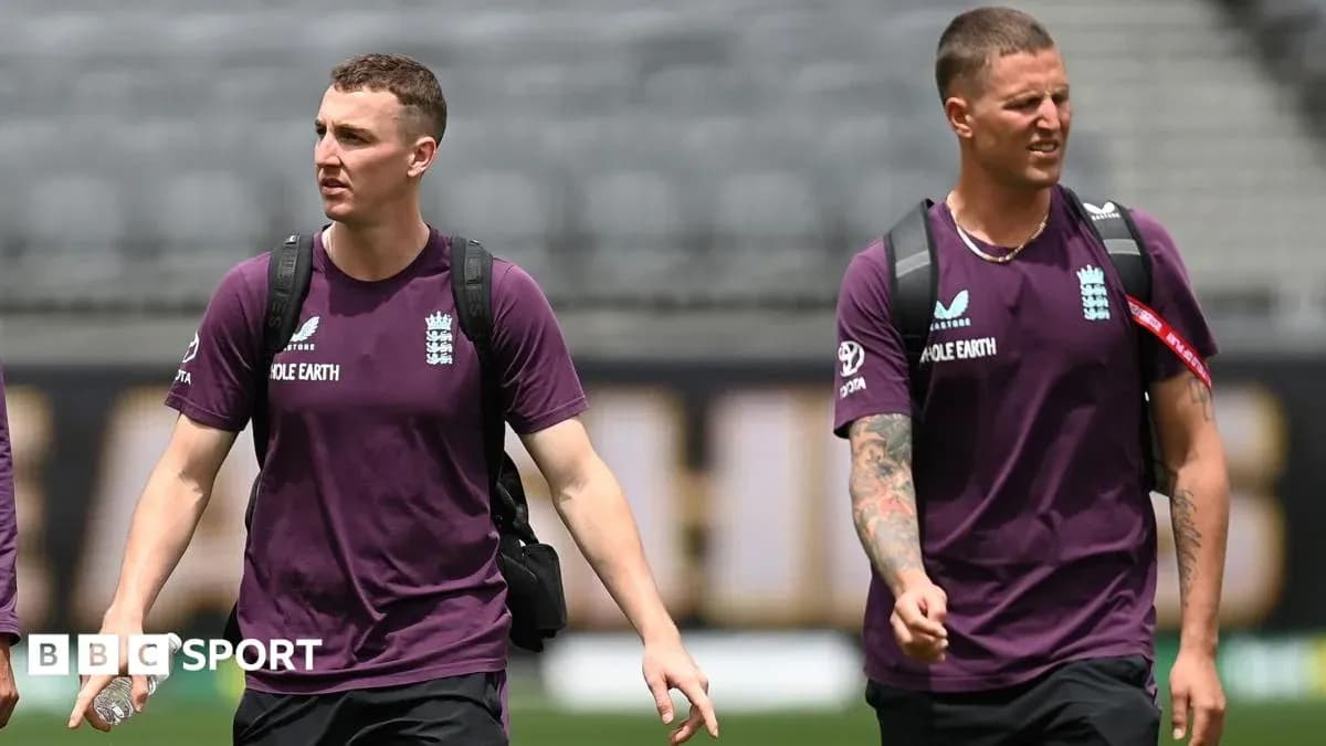 Two England cricketers walking in team shirts Two England cricketers walking in team shirts