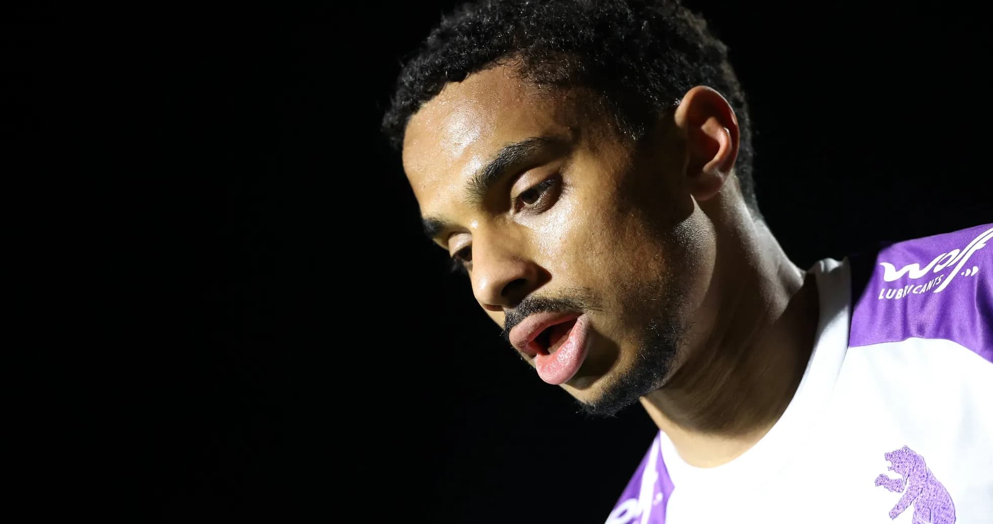 Player looking down, wearing a team jersey Player looking down, wearing a team jersey