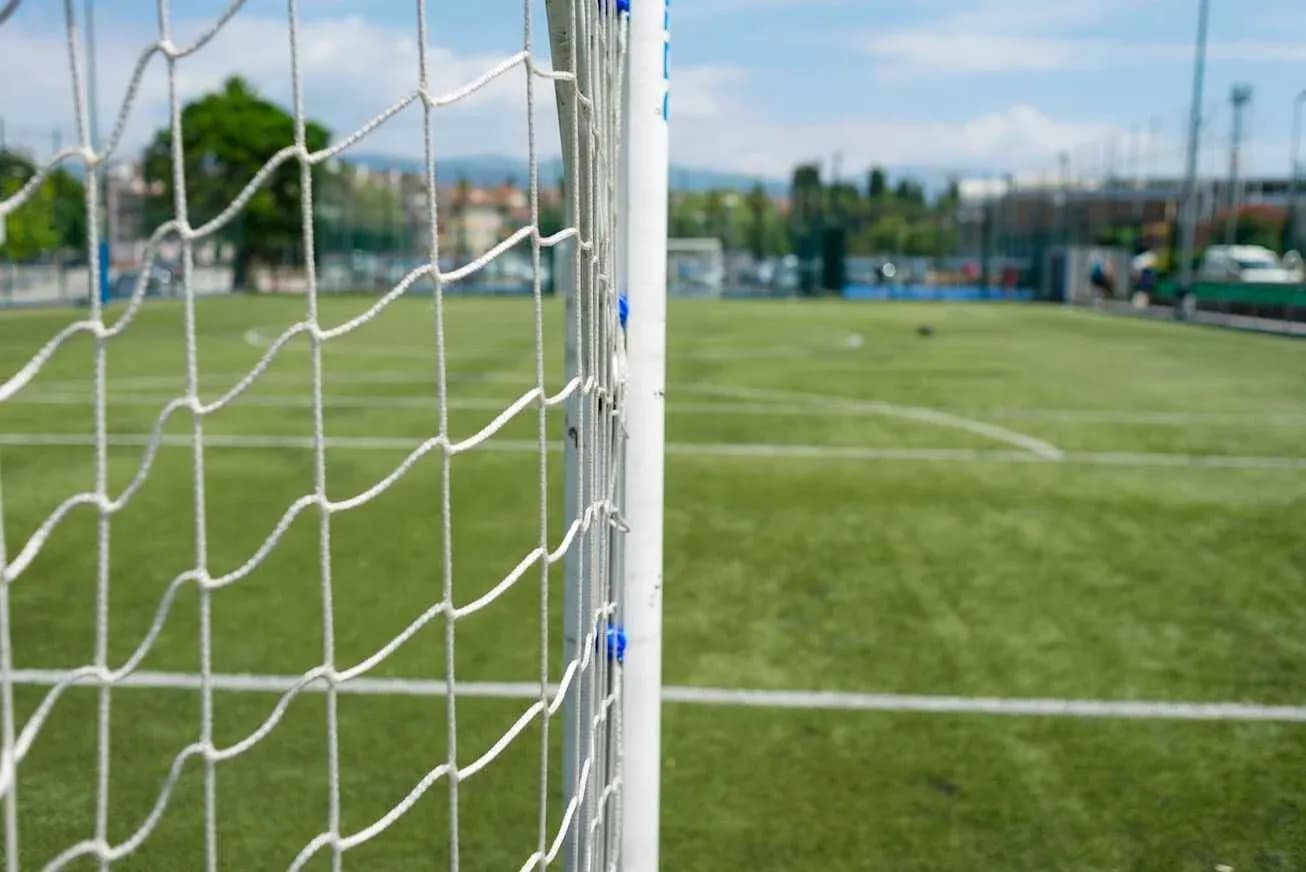 Close-up of soccer goal on green field Close-up of soccer goal on green field