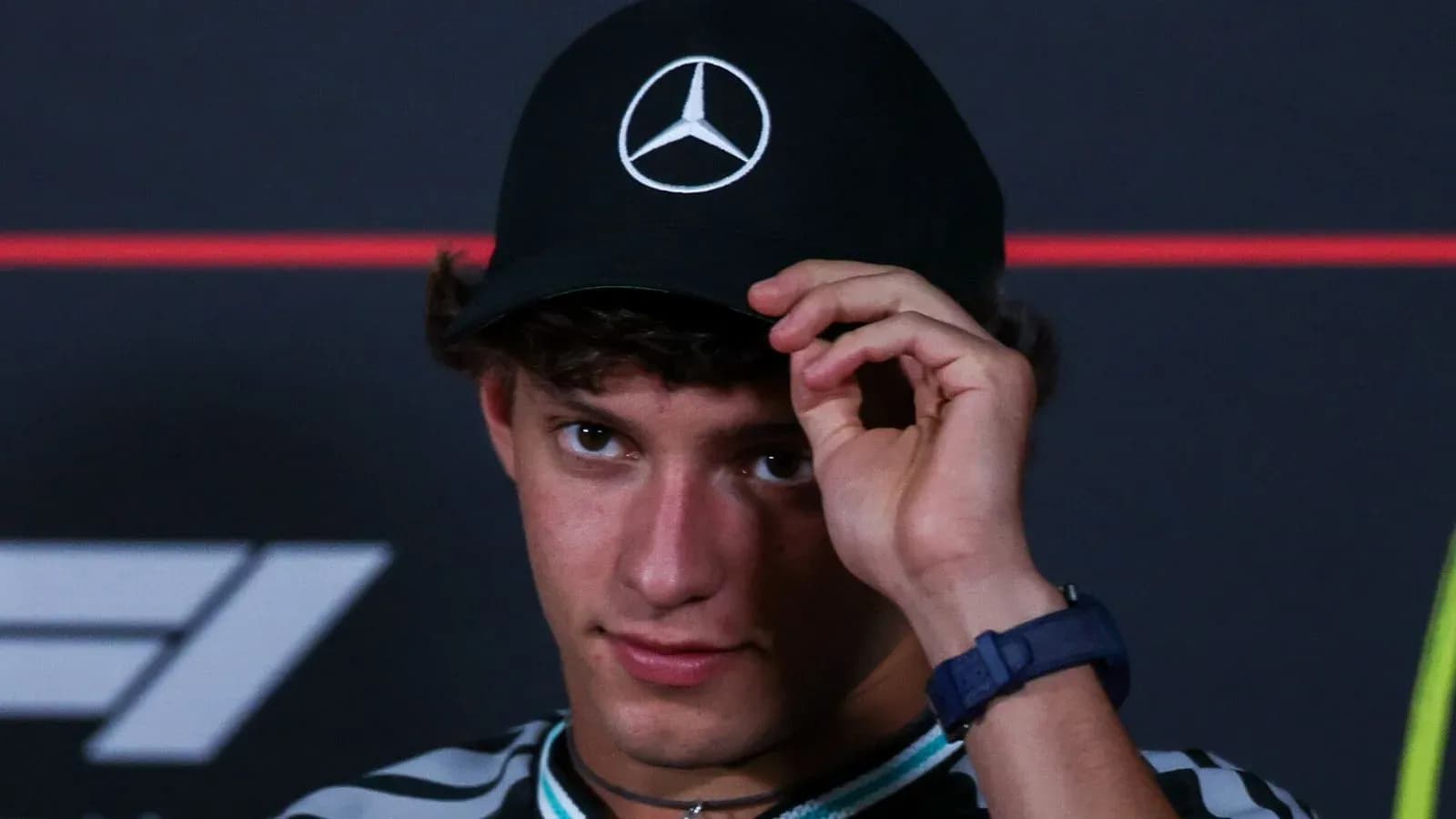Young driver adjusting his Mercedes cap at event Young driver adjusting his Mercedes cap at event