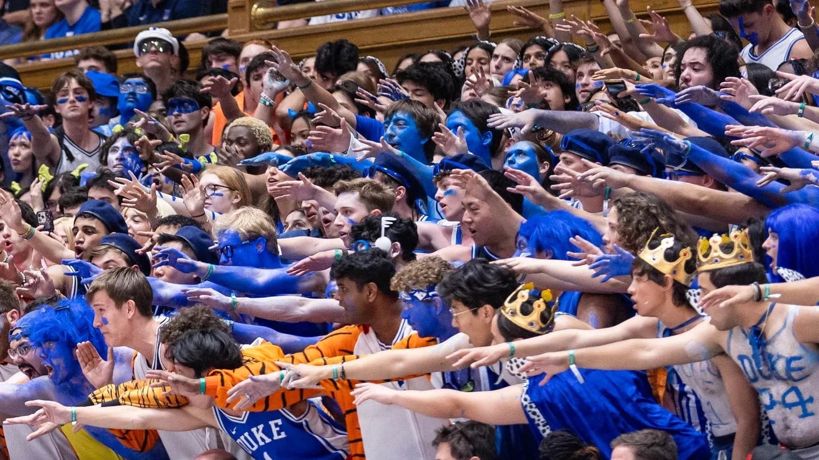 Duke fans in blue body paint cheering during game Duke fans in blue body paint cheering during game